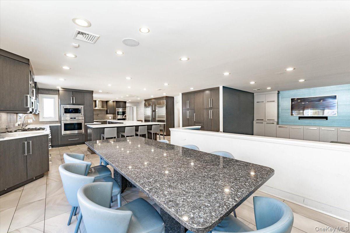 22 Larch Hill Road Lawrence, NY 11559 - Photo 8 of 31 a large kitchen with kitchen island a table and chairs in it