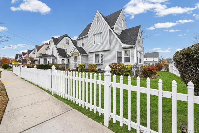 a front view of white house with a small yard