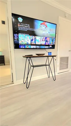 a view of a livingroom with a piano and wooden floor