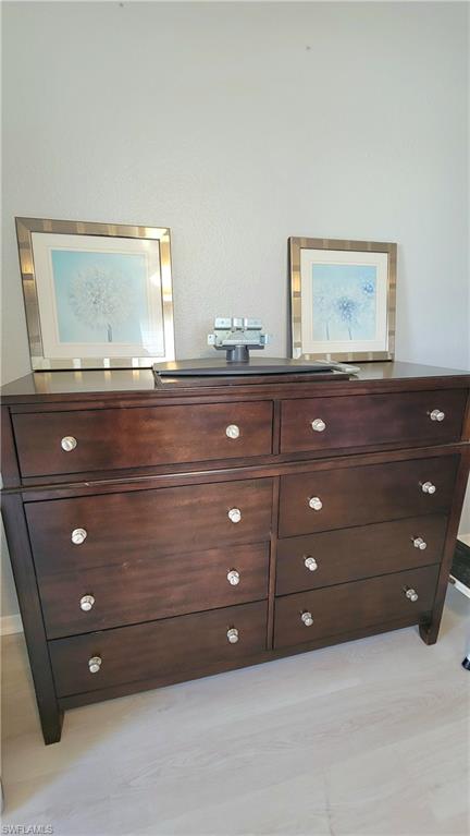 300 Valley Stream Drive, Unit A7 Naples, FL 34113 - Photo 29 of 34 a room with a dresser and a mirror
