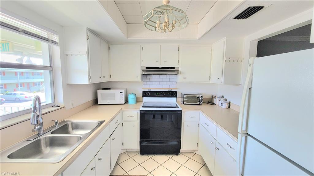 300 Valley Stream Drive, Unit A7 Naples, FL 34113 - Photo 33 of 34 a kitchen with a sink stove and refrigerator