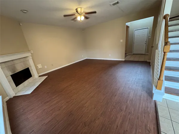 a view of a livingroom with wooden floor and a ceiling fan
