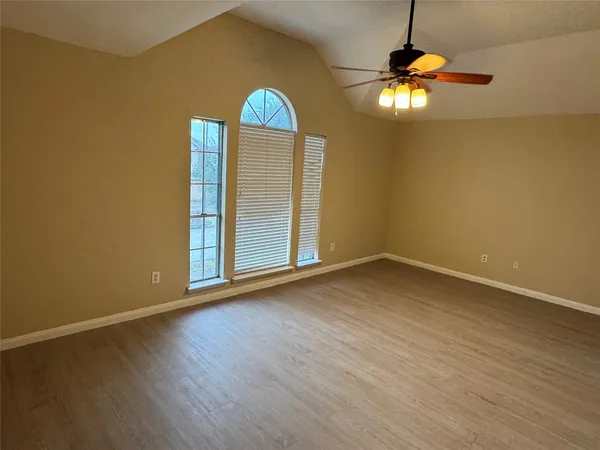 an empty room with wooden floor painted walls and chandelier