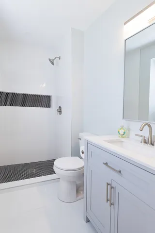 a bathroom with a sink a toilet and a mirror