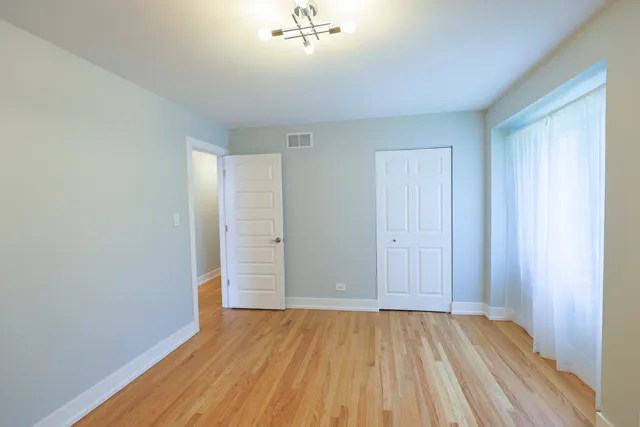 a view of a room with wooden floor and a window