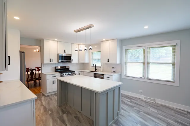 a kitchen with a stove a sink a refrigerator and cabinets