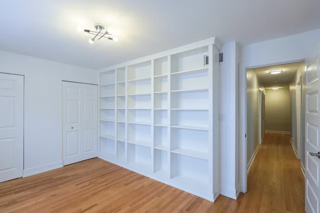 a view of empty room with wooden floor and cabinet