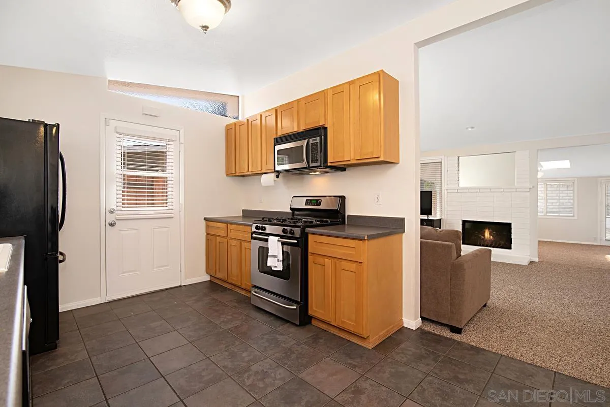 13836 Powers Road Poway, CA 92064 - Photo 11 of 27 a kitchen with stainless steel appliances granite countertop a stove top oven a refrigerator a sink and a microwave