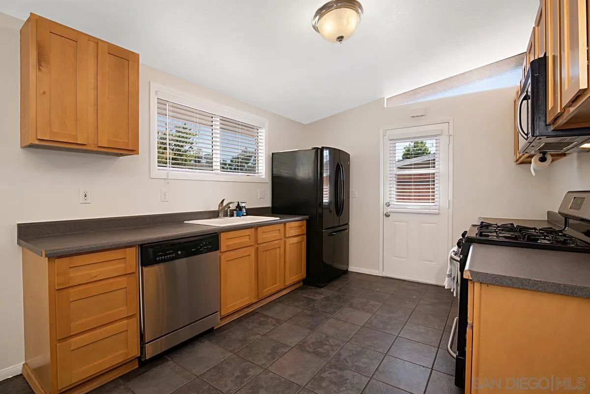 13836 Powers Road Poway, CA 92064 - Photo 8 of 27 a kitchen with stainless steel appliances granite countertop a stove a sink dishwasher and a refrigerator with wooden cabinets