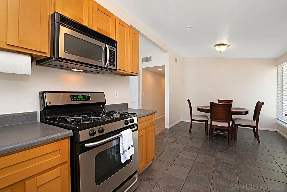 13836 Powers Road Poway, CA 92064 - Photo 9 of 27 a kitchen with a stove a microwave and wooden cabinets