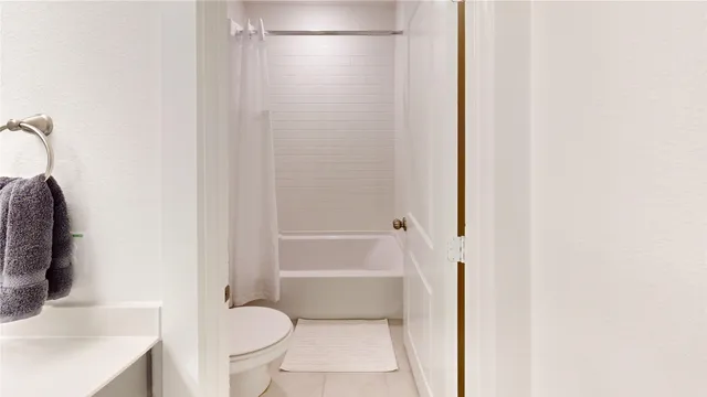 a spacious bathroom with a granite countertop sink a mirror and a bathtub