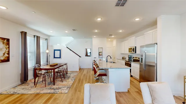 a living room with furniture a kitchen view and a refrigerator