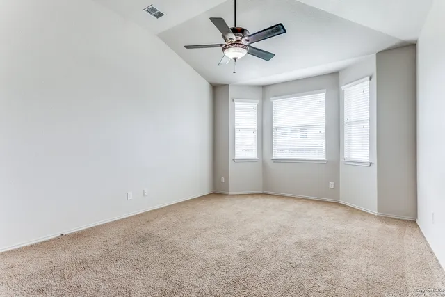 an empty room with windows and fan