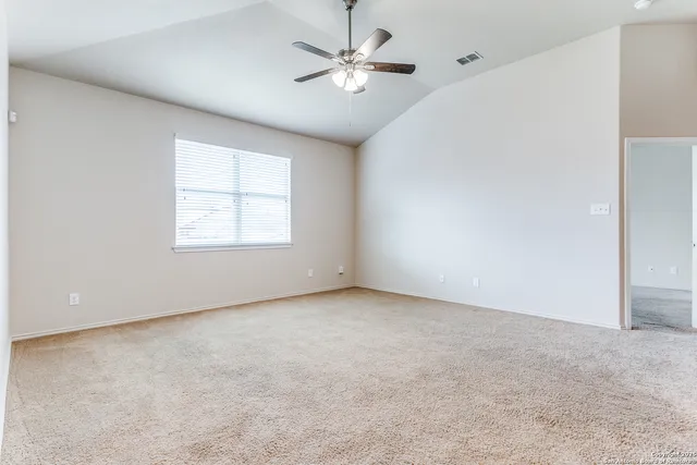 an empty room with windows and fan