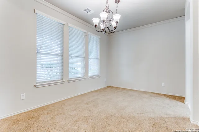 en empty room with windows and chandelier