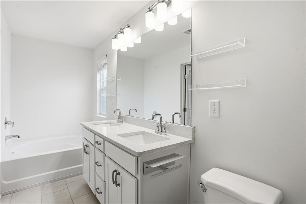 6360 Princeton Ridge Drive, Unit 6360 Lithonia, GA 30058 - Photo 12 of 16 a bathroom with a sink a toilet a mirror and bathtub