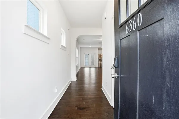 a view of a hallway with wooden floor and staircase