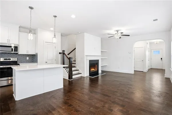 a kitchen with refrigerator a microwave and white cabinets