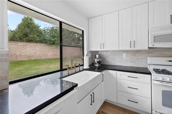 a kitchen with white cabinets and white appliances