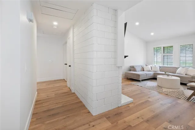 a view of a hallway with wooden floor and closet