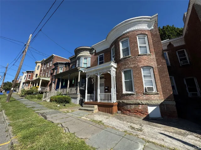 a view of a brick house with many windows