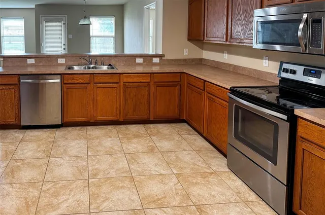 a kitchen with stainless steel appliances granite countertop a stove a sink and a microwave