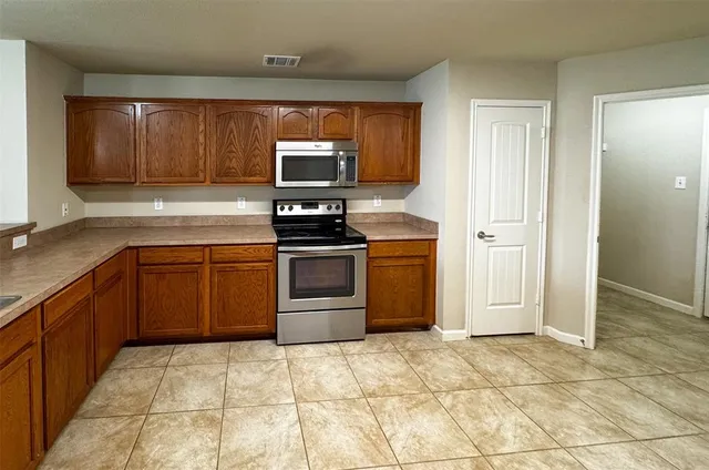 a kitchen with stainless steel appliances granite countertop a stove a sink and a refrigerator
