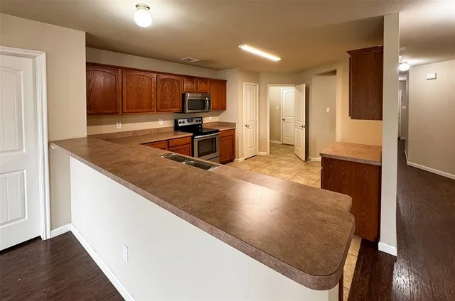 a kitchen with stainless steel appliances granite countertop a sink a stove and a refrigerator