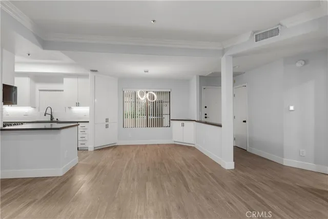a view of a kitchen with stainless steel appliances granite countertop a stove and a wooden floors