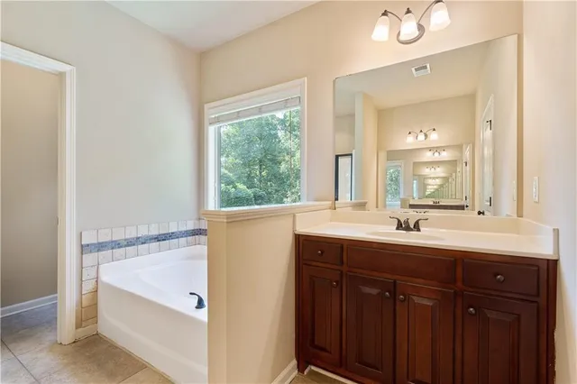 a bathroom with a double vanity sink and mirror with bathtub