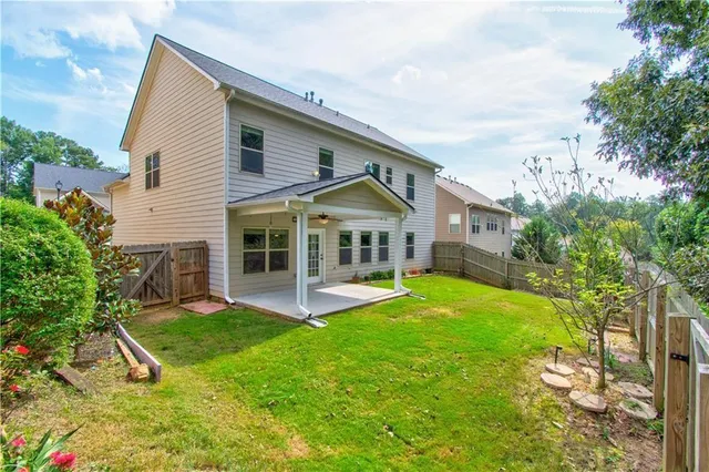 a view of a house with a yard and sitting area