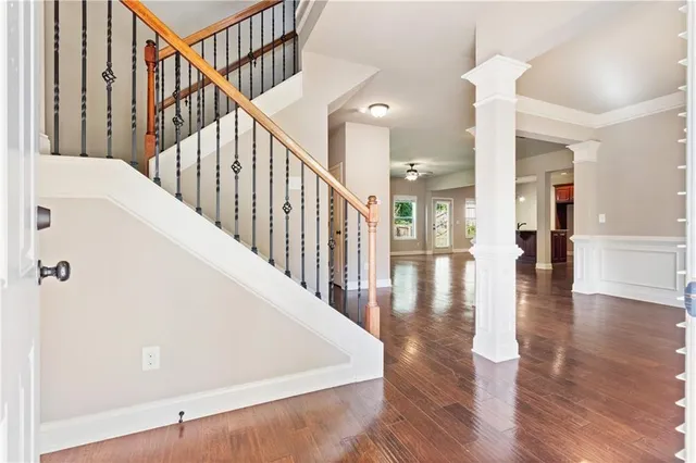 a view of staircase with lots of frames on wall and wooden floor