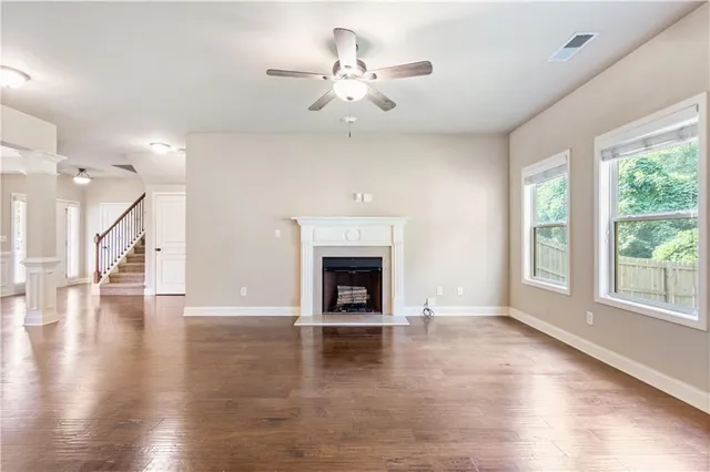 wooden floor fireplace and windows in an empty room