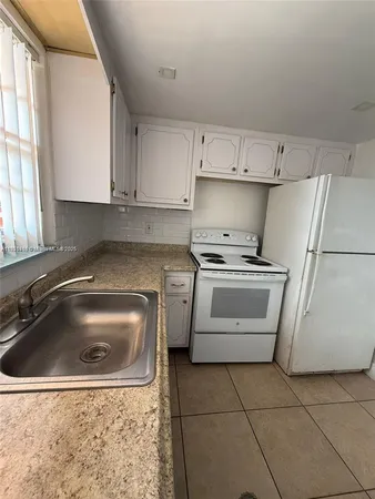 a utility room with cabinets washer and dryer