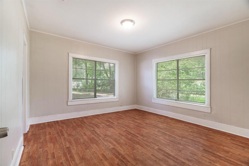 1358 Bonham Street Paris, TX 75460 - Photo 11 of 19 a view of an empty room with wooden floor and a window