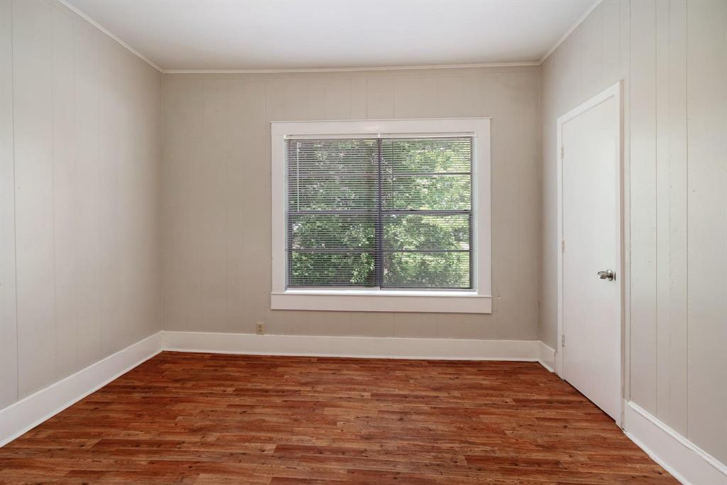 1358 Bonham Street Paris, TX 75460 - Photo 16 of 19 a view of an empty room with wooden floor and a window