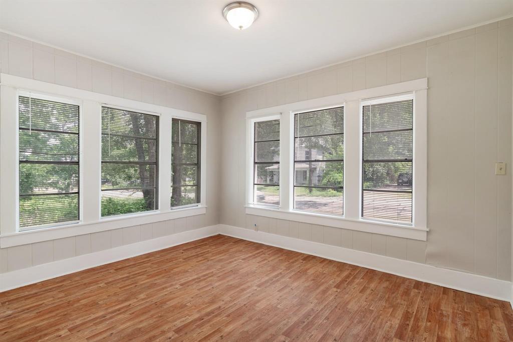 1358 Bonham Street Paris, TX 75460 - Photo 17 of 19 an empty room with wooden floor and windows