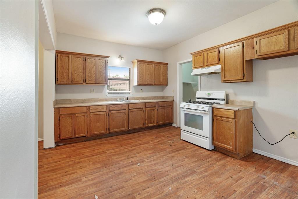 1358 Bonham Street Paris, TX 75460 - Photo 8 of 19 a kitchen with white cabinets and white appliances