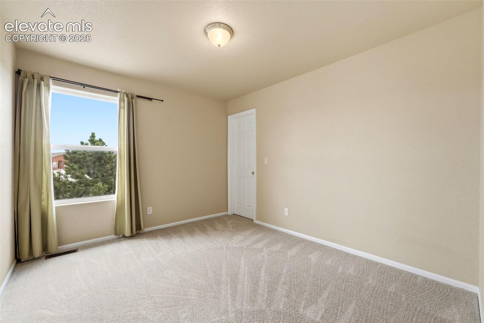 7274 Red Cardinal Loop Colorado Springs, CO 80908 - Photo 13 of 33 Recessed window with exterior scenery, overhead lighting fixture, light-toned wall paint, and neutral carpeting