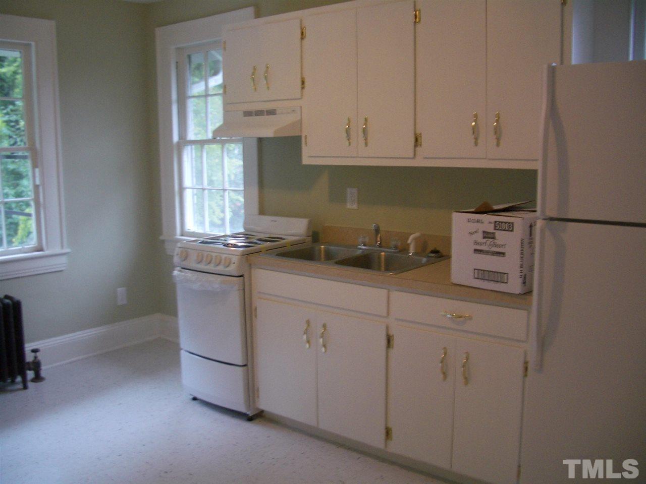 1225 Old Wake Forest Road Raleigh, NC 27604 - Photo 8 of 11 a kitchen with stainless steel appliances white cabinets and a refrigerator