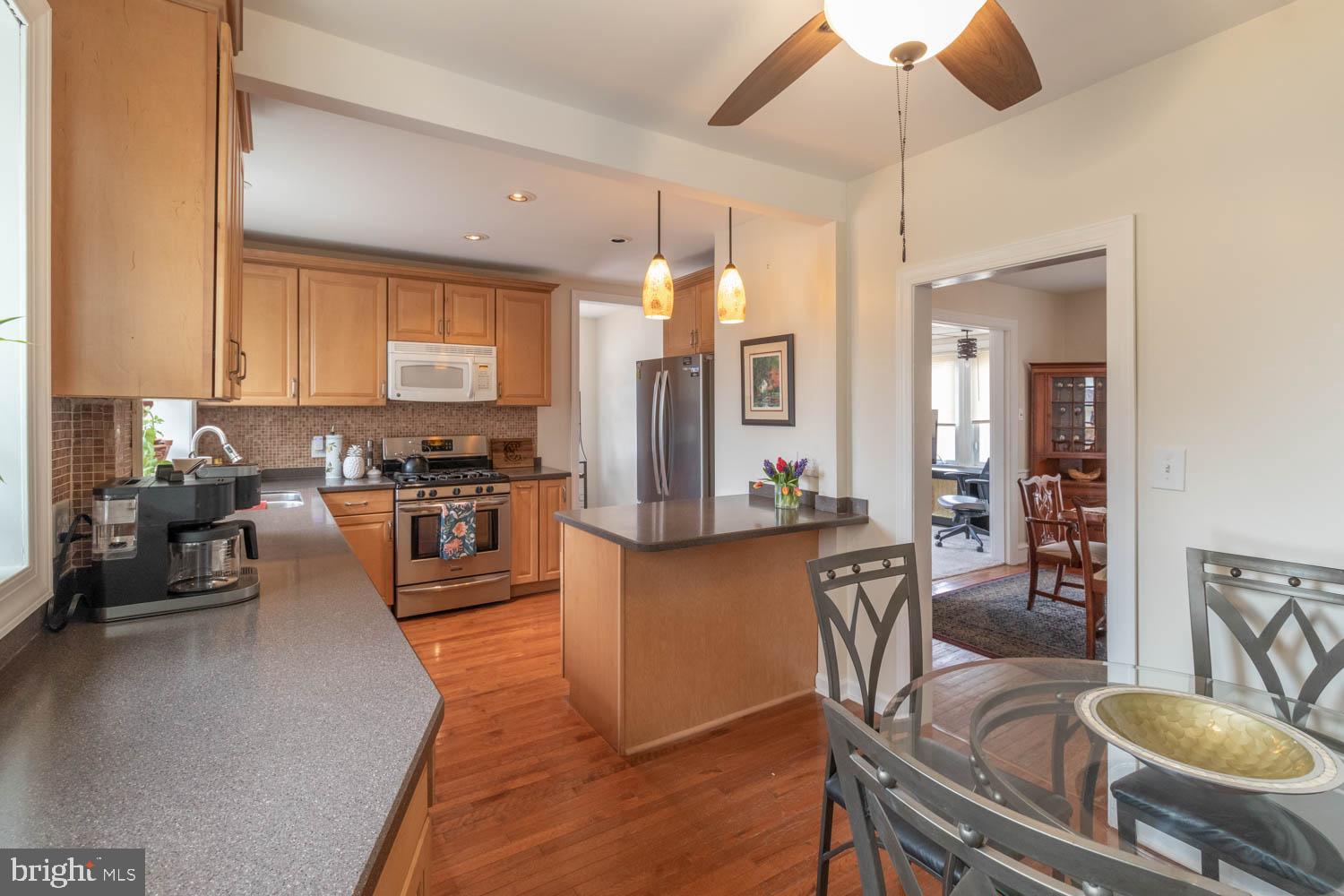 412 Oxford Road Havertown, PA 19083 - Photo 14 of 30 a kitchen with stainless steel appliances granite countertop a stove top oven a sink a dining table and chairs with wooden floor