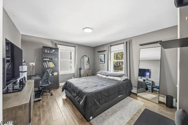 a bedroom with a large bed a flat tv screen and a dresser