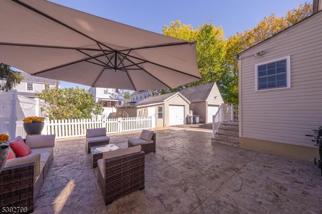 a view of a patio with a table and chairs under an umbrella