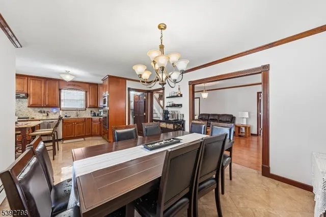 a dining room with wooden floor a chandelier a wooden table and chairs