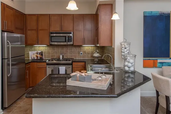 a kitchen with kitchen island granite countertop a sink a stove and a refrigerator