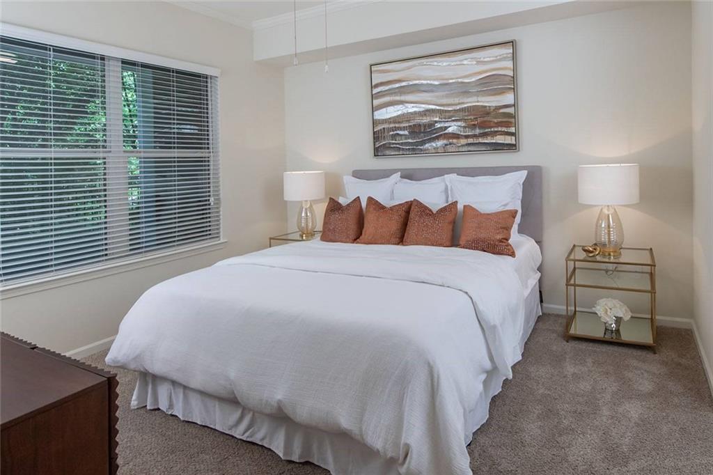 3443 Kingsboro Road Northeast, Unit 1202 Atlanta, GA 30326 - Photo 5 of 17 a bedroom with a bed and a night stand