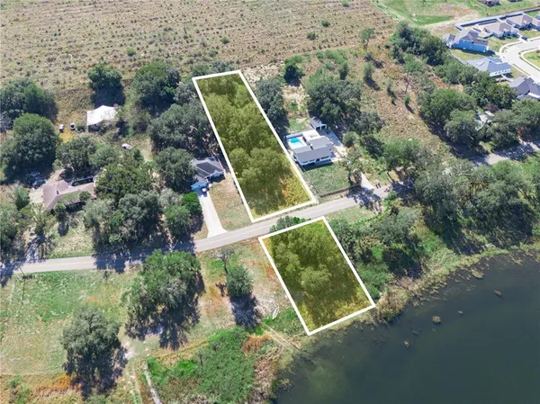 an aerial view of a residential houses with yard