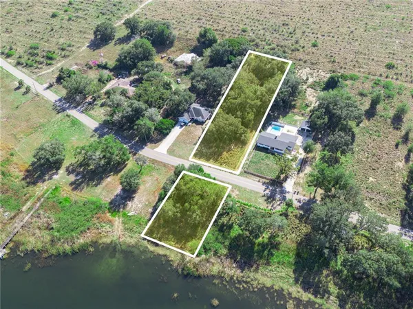 an aerial view of a house with a yard and lake view