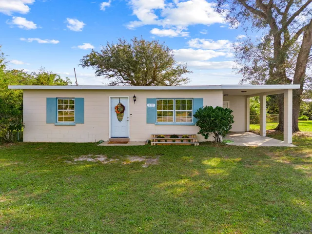 a view of a house with backyard and sitting area