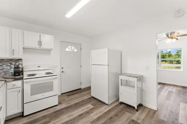 a kitchen with white cabinets and white appliances